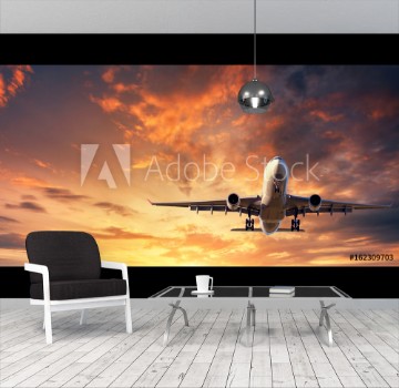Picture of Landing airplane Landscape with white passenger airplane is flying in the blue sky with clouds at colorful sunset Travel background Passenger airliner Business trip Commercial aircraft Concept